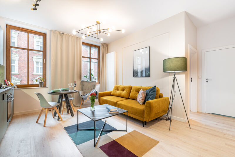 Living room with yellow sofa in a renovated tenement